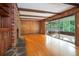 Open living room with a brick fireplace, wood paneling, hardwood floors and screened porch access at 3916 Ridgewood Se Dr, Smyrna, GA 30080