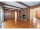 Bright living room featuring a brick fireplace, wood paneling, and hardwood floors at 3916 Ridgewood Se Dr, Smyrna, GA 30080