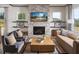 Cozy living room with a stone fireplace, built-in shelves, comfortable seating, and abundant natural light from large windows at 4850 Summerchase Ln, Cumming, GA 30028