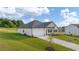 View of a single-story home with attached garage, side yard and manicured lawn with a beautiful blue sky at 648 Kimberwick Dr, Locust Grove, GA 30248