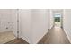 Hallway with laundry room, front door, hardwood floors and white trim at 648 Kimberwick Dr, Locust Grove, GA 30248