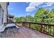 Wooden deck with picnic table is perfect for outdoor gatherings, offering serene views of surrounding greenery and the blue sky at 12095 Cameron Dr, Duluth, GA 30097