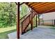 Exterior view of wood stairs leading down from the deck, complemented by lush greenery and a black metal fence at 12095 Cameron Dr, Duluth, GA 30097