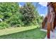 Manicured backyard lawn with lush landscaping and stairs leading to the deck. Plenty of privacy from mature trees at 12095 Cameron Dr, Duluth, GA 30097