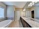 Elegant bathroom with double vanity, granite countertop, and soaking tub by the window at 12095 Cameron Dr, Duluth, GA 30097