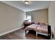 This bedroom features wood floors, neutral walls, and a cozy bed with a small desk by the window at 12095 Cameron Dr, Duluth, GA 30097