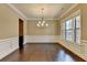 Spacious dining area with hardwood flooring, elegant lighting, and decorative wall trim at 12095 Cameron Dr, Duluth, GA 30097