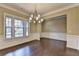 Elegant dining room featuring hardwood floors, crown molding, and a modern chandelier fixture at 12095 Cameron Dr, Duluth, GA 30097