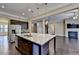Kitchen with island, granite counters, and stainless-steel appliances overlooks living room with fireplace at 12095 Cameron Dr, Duluth, GA 30097