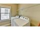 Functional laundry room with side-by-side washer and dryer, shelf, and window at 12095 Cameron Dr, Duluth, GA 30097