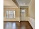 Bright living room featuring hardwood floors, wainscoting, and large windows that offer plenty of natural light at 12095 Cameron Dr, Duluth, GA 30097