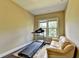 Cozy room with treadmill, rug, and a leather couch; potential for an office or workout area at 12095 Cameron Dr, Duluth, GA 30097