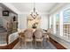 Well-lit dining room with wainscoting, hardwood floors, modern chandelier, and plantation shutters at 1667 Wehunt Se Pl # 11, Smyrna, GA 30082