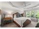 Inviting primary bedroom with tray ceilings, fan, and large windows overlooking the landscaped yard at 1667 Wehunt Se Pl # 11, Smyrna, GA 30082