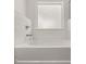 Bright bathroom with a tub, white tile surround, and modern fixtures at 1871 Lacebark Elm Way Way, Lawrenceville, GA 30045