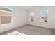 Bright bedroom featuring neutral walls, plush carpeting, and two windows offering ample natural light and backyard views at 1871 Lacebark Elm Way Way, Lawrenceville, GA 30045