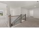 Bright upstairs hallway featuring neutral walls, plush carpeting, and a stylish wood and metal railing staircase at 1871 Lacebark Elm Way Way, Lawrenceville, GA 30045