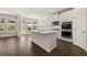 Spacious kitchen with white cabinets, stainless steel appliances, and a central island with seating, luxury vinyl plank flooring at 1871 Lacebark Elm Way Way, Lawrenceville, GA 30045