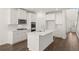 A bright kitchen with white cabinets, modern stainless steel appliances, and luxury vinyl plank flooring at 1871 Lacebark Elm Way Way, Lawrenceville, GA 30045