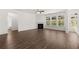 Open living room with hardwood floors, a fireplace, ceiling fan, and large windows at 1871 Lacebark Elm Way Way, Lawrenceville, GA 30045