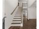 A bright staircase features wooden railings and steps leading to the second floor and luxury vinyl plank flooring at 1871 Lacebark Elm Way Way, Lawrenceville, GA 30045