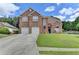 Charming two-story brick home with a well-manicured lawn and a long driveway leading to a two-car garage at 2678 Adair Trl, Dacula, GA 30019