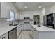 Bright kitchen features white cabinetry, stainless steel appliances, an island, and quartz countertops at 2678 Adair Trl, Dacula, GA 30019