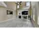 Spacious living area with a fireplace, a ceiling fan, many windows, and light-colored wood-look floors at 2678 Adair Trl, Dacula, GA 30019