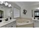 Bright bathroom showcasing a corner tub, tile floors, dual vanities, and a window at 2678 Adair Trl, Dacula, GA 30019