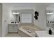 Bright main bathroom featuring a corner tub, tile floors, and dual vanities at 2678 Adair Trl, Dacula, GA 30019
