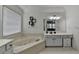 Bright bathroom featuring a corner tub, tile floors, dual vanities, and a window at 2678 Adair Trl, Dacula, GA 30019