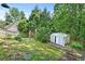 Leafy backyard with a metal storage shed and room for outdoor recreation surrounded by tall trees at 2700 White Blossom Ln, Suwanee, GA 30024
