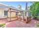 Charming backyard with brick patio, deck, and a gazebo covered in beautiful hanging flowers at 2700 White Blossom Ln, Suwanee, GA 30024