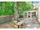 Outdoor deck space with a built-in bench, mature trees, and charming birdhouses at 2700 White Blossom Ln, Suwanee, GA 30024