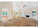 Open-concept living area with a fireplace, ceiling fan and doors to outdoor spaces at 2700 White Blossom Ln, Suwanee, GA 30024