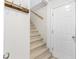 Stairwell has carpeted stairs with wooden hand rail and a coat rack next to the entry door at 2700 White Blossom Ln, Suwanee, GA 30024