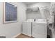 Functional laundry room equipped with a side-by-side washer and dryer, plus shelving for storage at 5595 Rosehall Pl, Atlanta, GA 30349