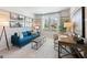 Inviting living room with a blue sofa, natural light, and a workspace at 5595 Rosehall Pl, Atlanta, GA 30349