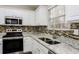 Modern kitchen featuring stainless steel appliances, granite countertops, and white cabinetry at 820 Tradd Ct, Stone Mountain, GA 30087