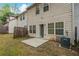 View of the backyard featuring a small patio and a well-maintained lawn at 1341 Rogers Trce, Lithonia, GA 30058