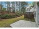 Spacious backyard with a concrete patio, wooden fence, and mature trees at 1341 Rogers Trce, Lithonia, GA 30058