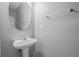 Powder room featuring a pedestal sink, a round mirror, and neutral wall color at 1341 Rogers Trce, Lithonia, GA 30058