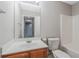 Bright bathroom features a large mirror, single sink vanity, and combined tub and shower at 1341 Rogers Trce, Lithonia, GA 30058