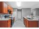 Well-lit kitchen with stainless steel appliances, warm cabinets, and grey countertop at 1341 Rogers Trce, Lithonia, GA 30058