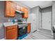 Galley kitchen featuring modern appliances, warm cabinets, and neutral flooring at 1341 Rogers Trce, Lithonia, GA 30058