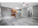 Open concept living room with wood-look flooring, ceiling fan, and modern kitchen at 1341 Rogers Trce, Lithonia, GA 30058