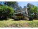 Back of house features an elevated deck with stairs, surrounded by lush greenery and yard at 535 Toonigh Rd, Woodstock, GA 30188