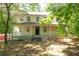 Two-story home with a welcoming front porch, black front door, and surrounded by mature trees in a serene setting at 535 Toonigh Rd, Woodstock, GA 30188