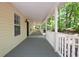 Covered porch with wood flooring, white railings, and views of the home's natural surroundings at 535 Toonigh Rd, Woodstock, GA 30188