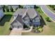 Beautiful home with manicured landscaping, three-car garage, and well-maintained lawn showcasing exceptional curb appeal at 7575 Old Camp Lndg, Cumming, GA 30040